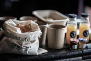 Brunch Box des Hotel Grischa mit Gipfeli im Stoffsack, Kaffeebechern und Säften