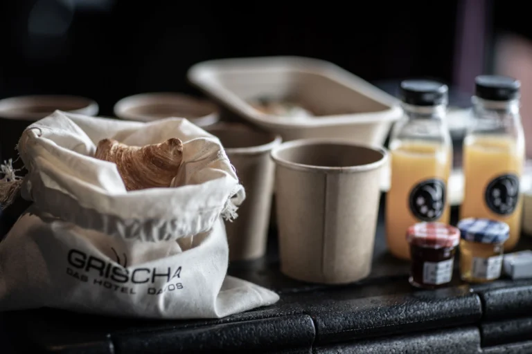 Brunch Box des Hotel Grischa mit Gipfeli im Stoffsack, Kaffeebechern und Säften